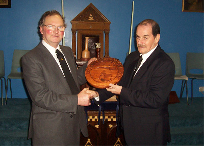 Bro. Hutcheon presenting the wooden Mark Token to Bro. Southworth